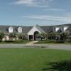 A view of the clubhouse with putting green in foreground at Willow Creek Golf Course